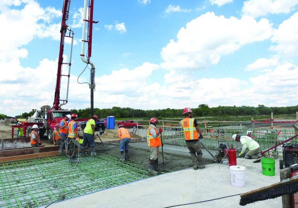 THIS CREW FROM AMES CONSTRUCTIOn worked on pouring concrete approach panels to the bridge deck above the new dam at Lake Bronson State Park on Thursday, June 4. Crews are also working on diverting the stream channel below the dam and building a coffer dam around the former structure to prepare for its demolition. (Enterprise photo by Anna Jauhola)